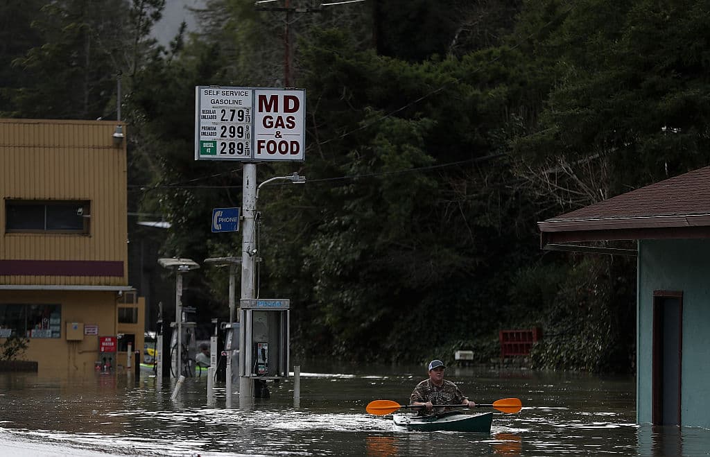 Un residente rema su kayak a través de las aguas de la inundación en Guerneville.