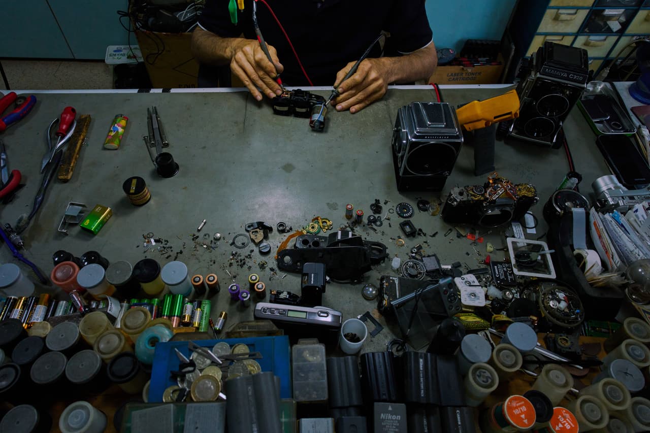 Un artesano reparador de cámaras Ata Çetinkaya trabaja en su taller en el distrito comercial de Sirkeci, en Estambul.
