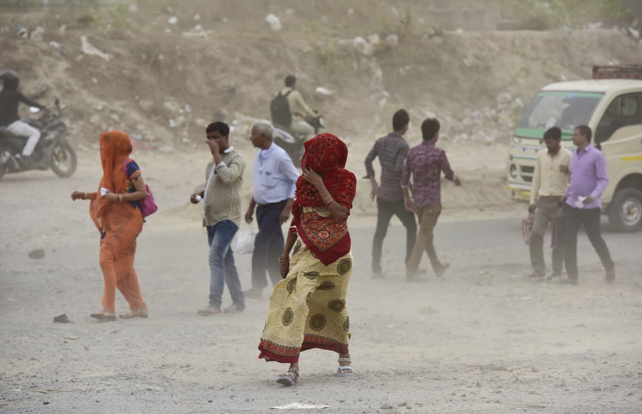 La gente se cubre durante la tormenta de polvo en Noida, India. ç
