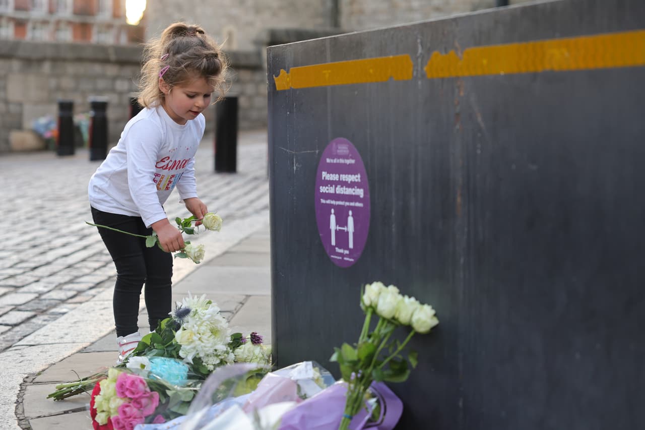 Una niña deja unas rosas blancas en la calle frente al palacio de Windsor. La muerte de la reina Isabel II deja temporalmente sin jefe de Estado a 130 millones de súbditos en el Reino Unido y otros 14 antiguos dominios del Imperio Británico. En sus 70 años de reinado, ella dio la mano a 15 primeros ministros de ese país.
