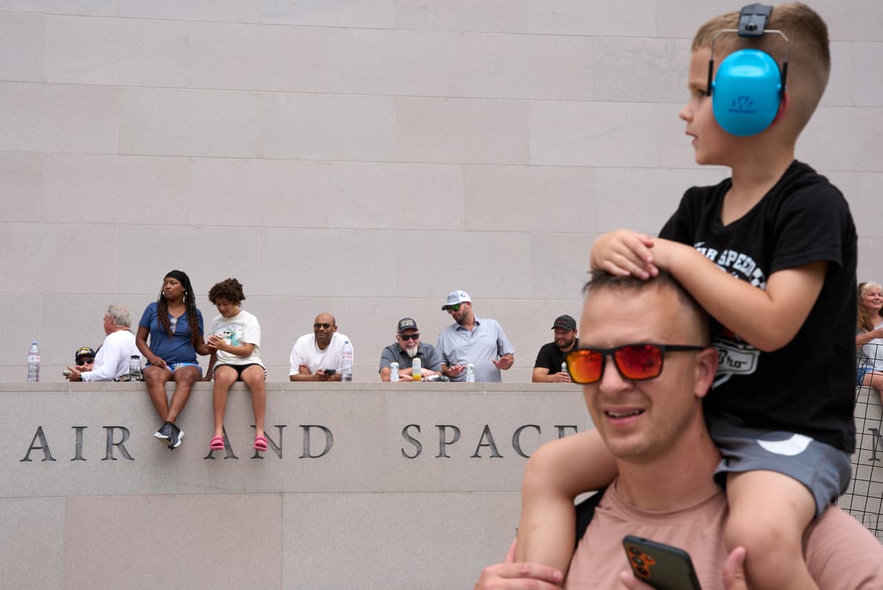 Los aficionados a las carreras se disputan una buena vista de los coches de carreras que practican junto al Museo Nacional del Aire y el Espacio del Smithsonian, antes del Gran Premio Freedom 250.