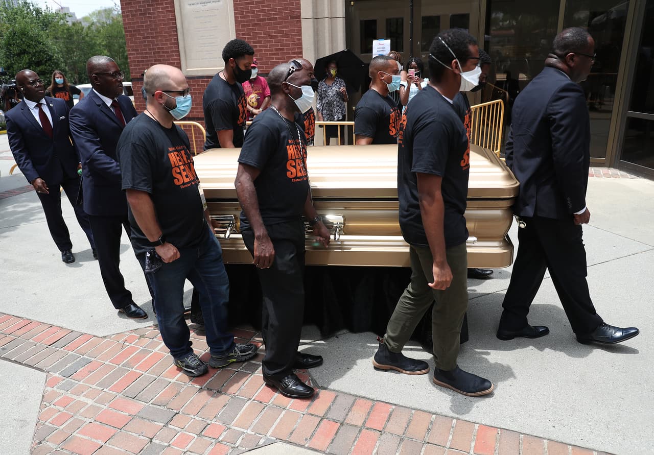 Un grupo de hombres cargan féretros con los restos de Rayshard Brooks para ingresar a la Iglesia Bautista Ebenezer. Brooks fue asesinado el 12 de junio por un oficial de policía de Atlanta después de una lucha durante una prueba de sobriedad en el estacionamiento de un restaurante de Wendy's.