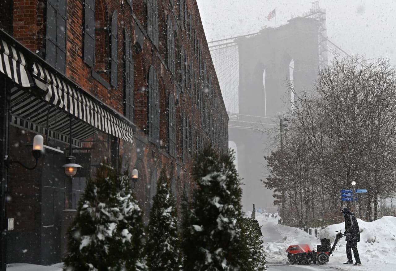 Un hombre utiliza un quitanieves para limpiar la calle en Brooklyn