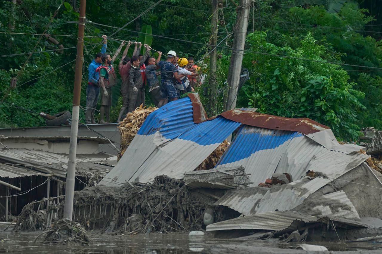 Los rescatistas instalan una cuerda para buscar sobrevivientes tras las inundaciones repentinas en el río Trishuli.