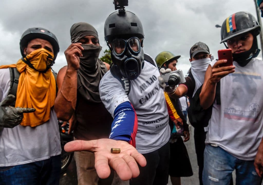 Manifestantes opositores muestran los casquillos de bala recogidos luego de la refriega con la Guardia Nacional.