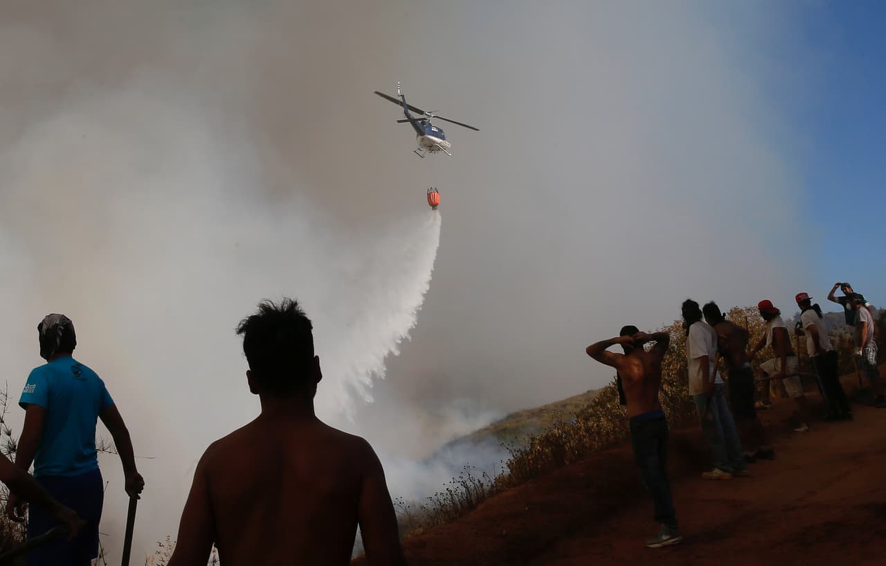 Bomberos y brigadas forestales combatían el fuego para evitar que alcanzara los campamentos, apoyados por aviones y helicópteros.