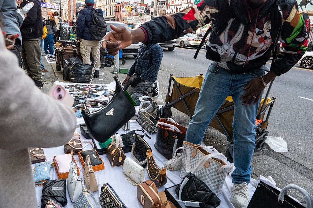No es secreto que, en la Ciudad de Nueva York,
<b>Canal Street, en el bajo Manhattan,</b> es el lugar donde vendedores ambulantes ofrecen réplicas de
<b>bolsos, relojes, cinturones, perfumes </b>y otros artículos de marcas de lujo. Por ejemplo, una persona interesada en
<b>un bolso Prada</b>, cuya versión original cuesta poco más de $2,000, allí puede pagar $50 por la 'fake'.
<br>
<br>Si un agente del Departamento de la Policía de Nueva York (NYPD) divisa la transacción, con toda probabilidad
<b><a href="https://www.univision.com/local/nueva-york-wxtv/operativos-consecutivos-vendedores-ambulantes-manhattan-2024-fotos" target="_blank">imponga una multa al vendedor e incaute la mercancía</a></b>. Este 2025, algunos de estos vendedores evitan también un encuentro con los agentes de Control de Inmigración y Aduanas (ICE).