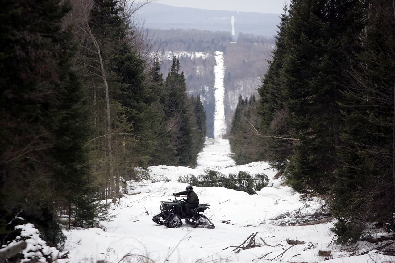 El camino de nieve en el bosque marca la frontera entre EEUU y Canadá (a la derecha) en Beecher Falls, Vermont.