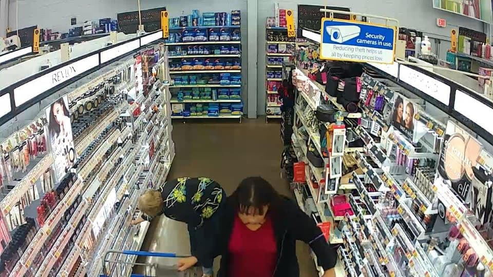 La sospechosa toma con una mano la cartera, mientras sigue manejando su carrito de compras por el pasillo de la farmacia.