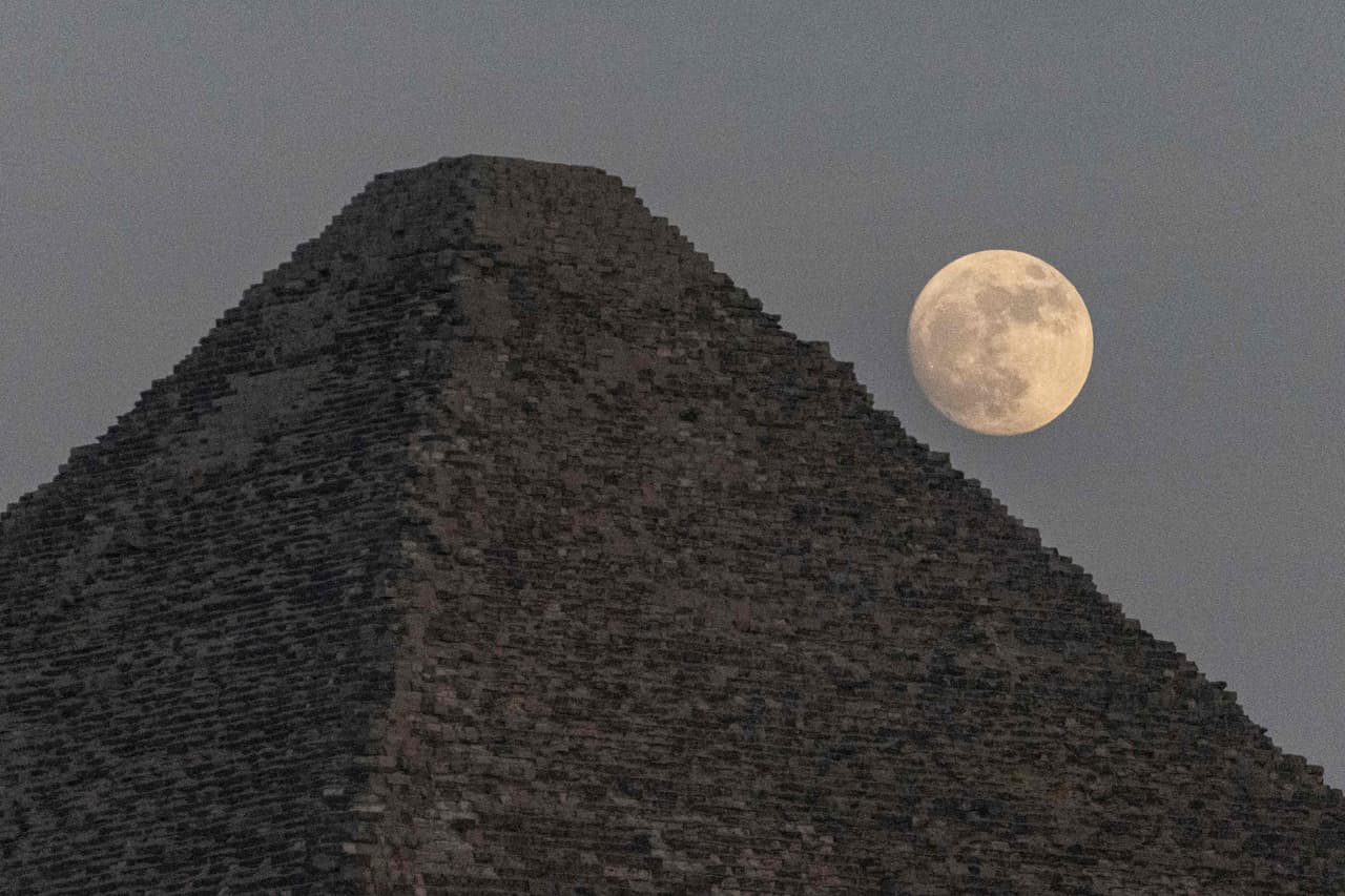 La tercera superluna de 2022, y también la más grande que se podrá visualizar este año, adorna el cielo nocturno desde este martes. En la foto, se ve detrás de la Gran Pirámide de Khufu, en Cheops, Egipto.