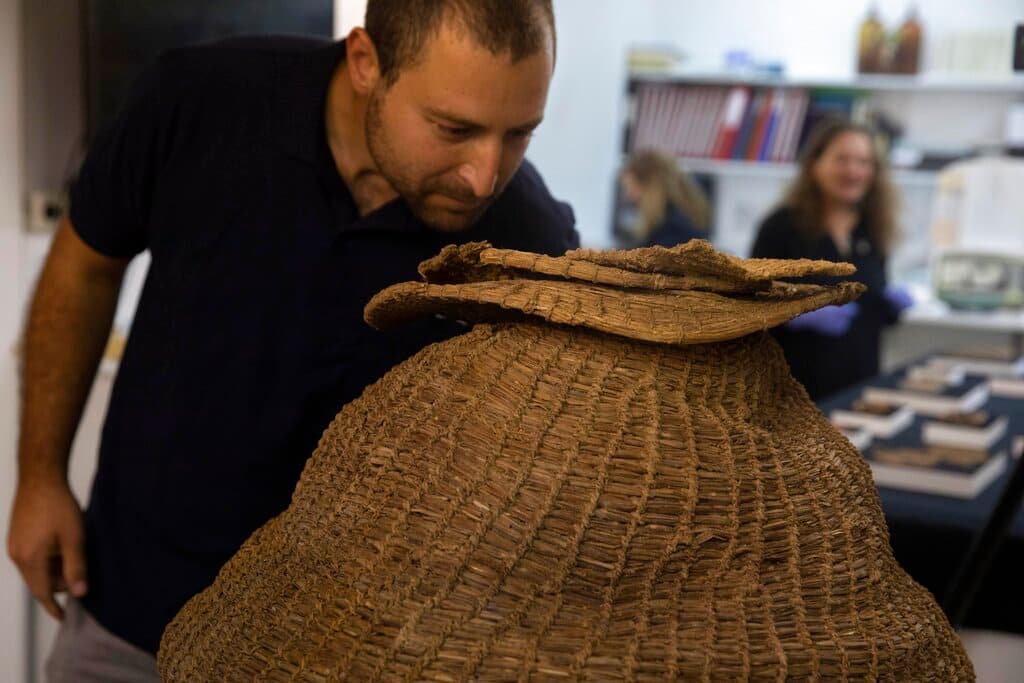 Además, en otra cueva de la zona se halló
<b>una cesta de hace unos 10,500 años</b>, de la época neolítica pre-cerámica. El objeto que en la imagen observa el arqueólogo Haim Cohene, se tejió con material vegetal, se preservó gracias al clima árido y podría ser "la más antigua del mundo", destacó la AAI.
