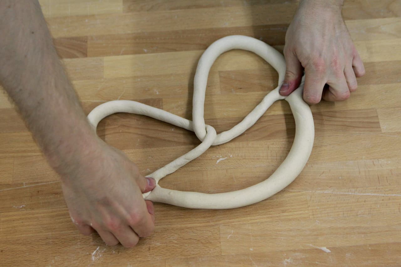 Con una cuchara de madera, haz caer la harina de los costados del recipiente y mezcla con el agua con levadura para formar una pasta blanda. Tapa con un paño de cocina y 
<b>deja esponjar unos 20 minutos</b>, hasta que fermente y forme espuma. 
<br>