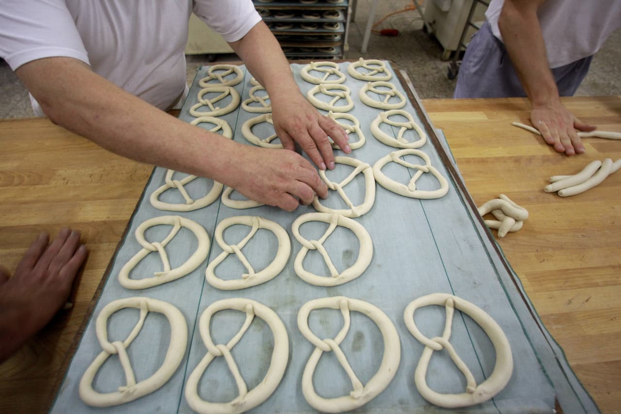 <b>Elaboración de la receta de pretzels o lazos salados</b>: Esparce la levadura en un tazón con 100ml de agua. Deja 5 minutos revolviendo para que se disuelva. Mezcla la harina y la sal en un recipiente grande. Haz un hoyo en el centro y vierte el agua con levadura.
<br>