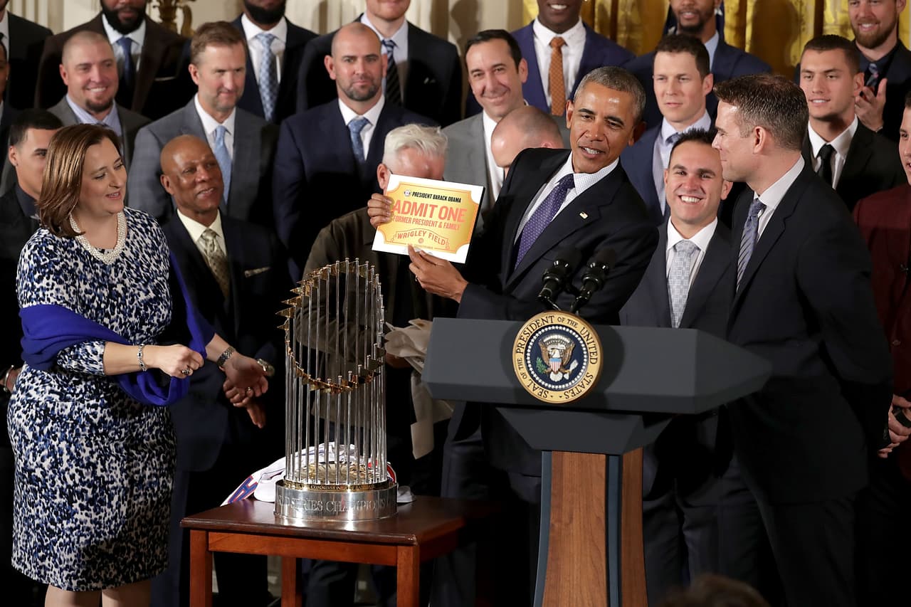 El presidente Obama sostiene su pase de por vida que le otorgó una de las dueñas de los Chicago Cubs, Laura Ricketts.