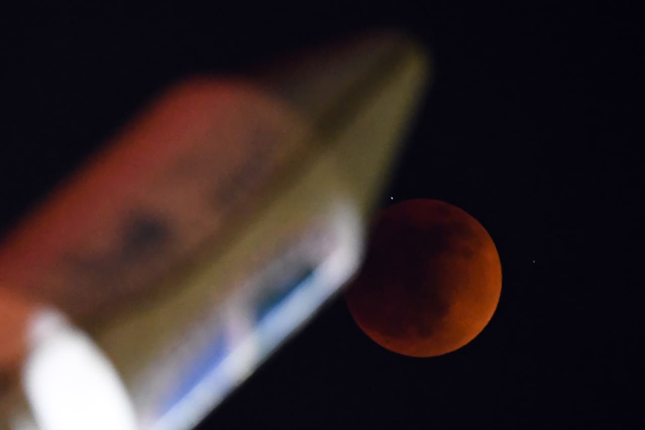 La luna de sangre y el eclipse lunar detrás del monumento de SpaceX Falcon Heavy en Hawthorne, California.
