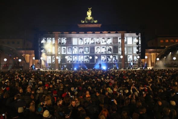 En la conmemoración también se proyectaron retratos de personas que murieron al intentar huir de Berlín Oriental a Berlín Occidental iluminan la Puerta de Brandenburgo durante una ceremonia de honor.