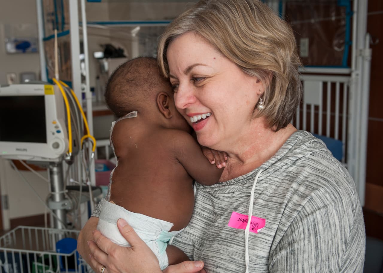 Nancy Swabb es la madre sustituta que se ha encargado del cuidado de la bebé Dominique luego de la cirugía. La niña volverá a África en los próximos días con su familia. De no operar a Dominique, los médicos estiman que hubiera podido presentar problemas de columna durante su crecimiento.