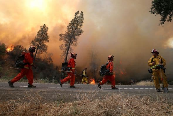 Bomberos caminan hacia a lo largo de la carretera interestatal 20.