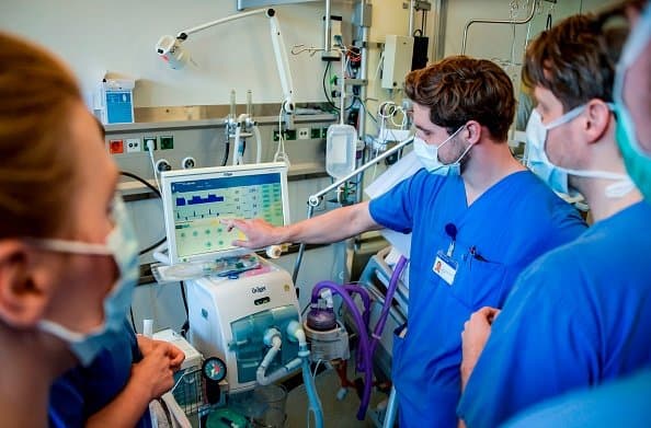 Doctors in a hospital examining a ventilator.