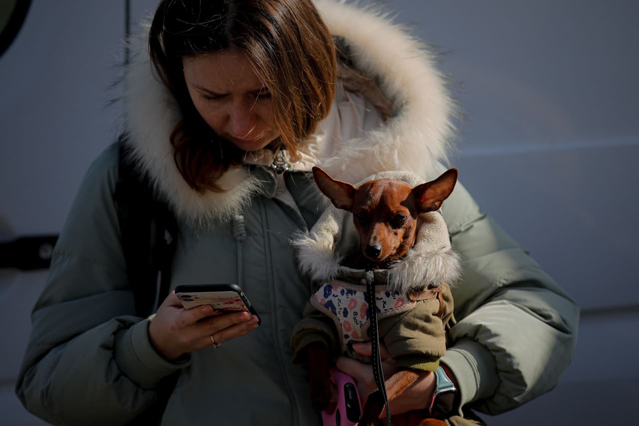 Una mujer sostiene a su perro después de cruzar la frontera hacia Rumania en Siret. La Comisión Europea anunció que está coordinando la ayuda para esta emergencia de la Unión Europea, y que está lista para asistir a los países fronterizos con Ucrania pertenecientes a la organización.