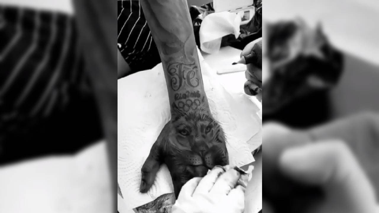 La palabra 'fé' y el logotipo de los JJOO de Río adornan el imponente león.