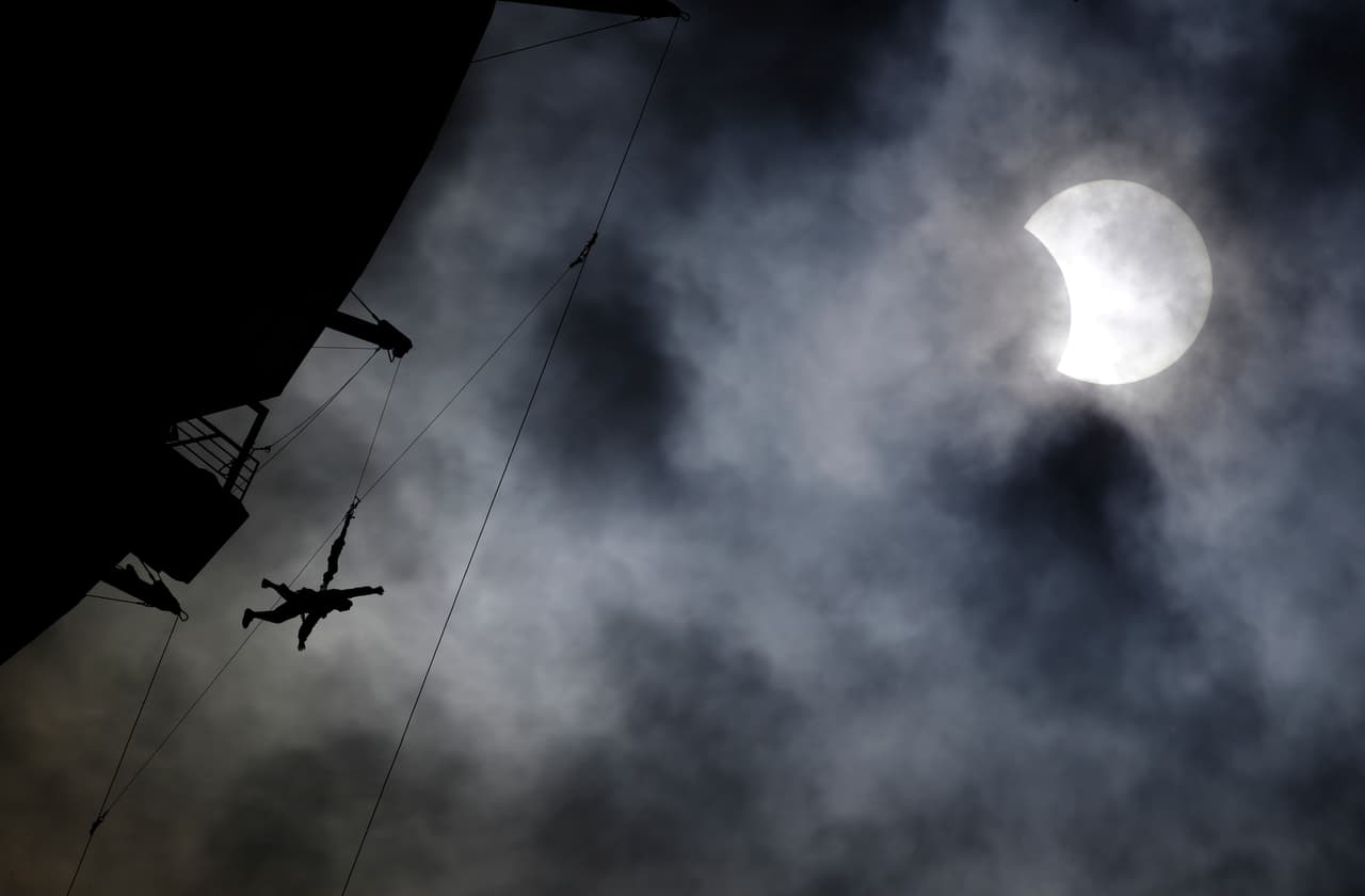 Un hombre salta desde la parte superior del hotel Stratosphere en Las Vegas, Nevada, a 829 pies de altura. Al fondo, la luna comienza a tapar al sol.