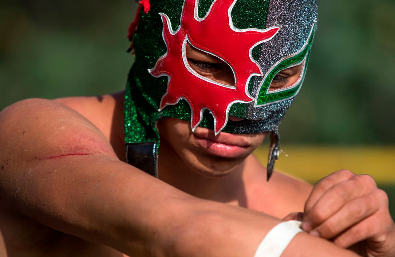 El luchador mexicano Sol minutos antes de su participación en el evento en las chinampas de Xochimilco en la Ciudad de México,
<b>en una presentación creativa y colorida que los gladiadores armaron para intentar combatir un poco los estragos económicos de la pandemia. </b>
<br>