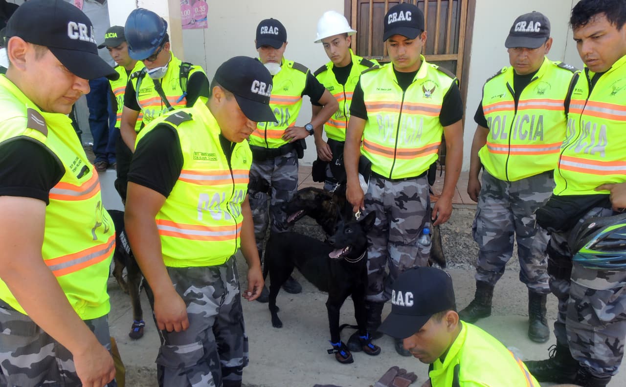 Un grupo de rescatistas se alista para entrar en un edificio en ruinas en la localidad ecuatoriana de Canoa.
