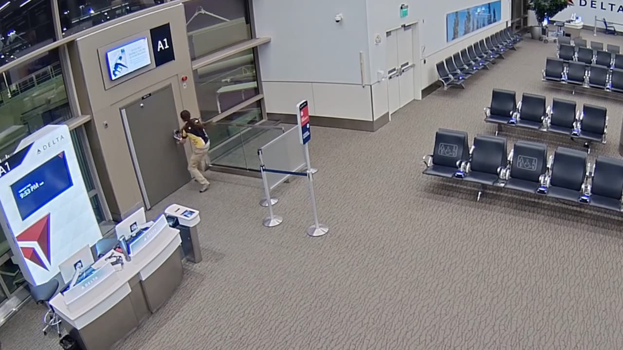 Cuando el intento de forzar la cerradura no resulta Efinger intenta romper una venta con sus zapatos, pero es sorprendido por personal del aeropuerto, por lo que busca otra salida.