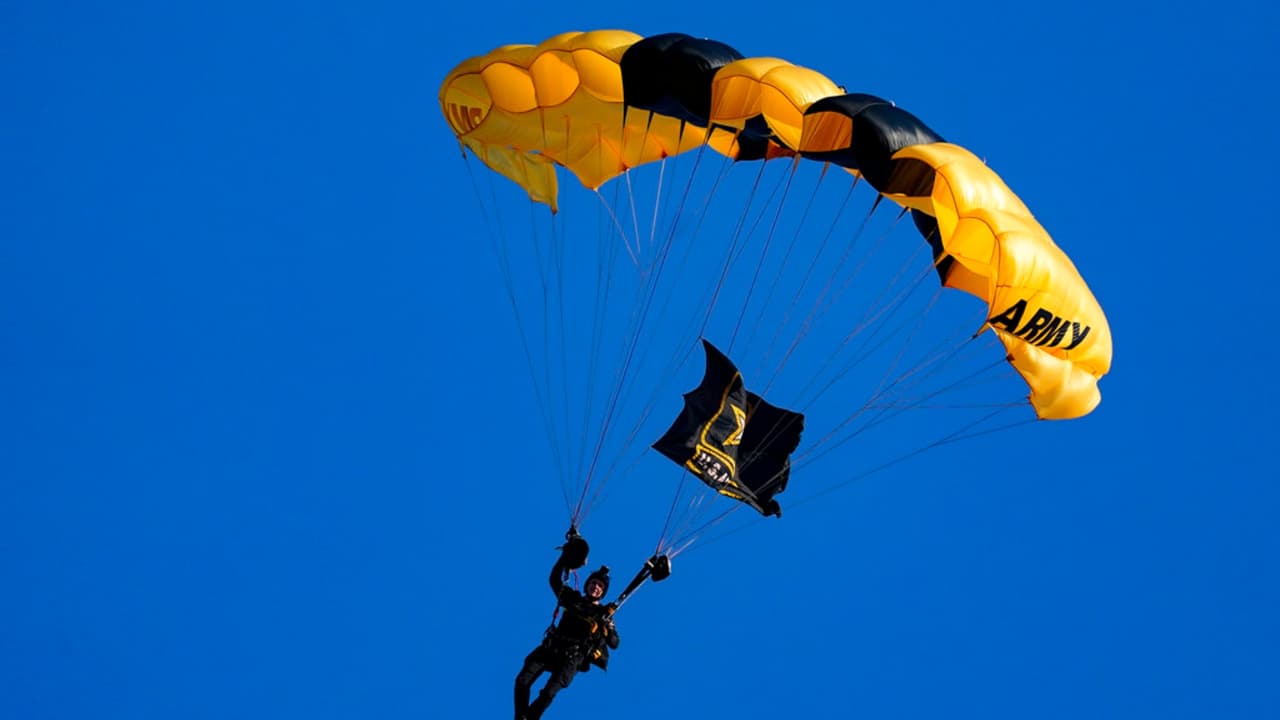 Un miembro del equipo de paracaidistas Golden Knights del Ejército de Estados Unidos desciende al National Park antes de un partido entre los Nacionales de Washington y los Diamondbacks de Arizona.