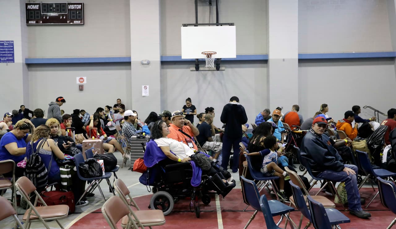 Residentes de Corpus Christi esperan en el gimnasio de una escuela secundaria su turno para abandonar la ciudad.