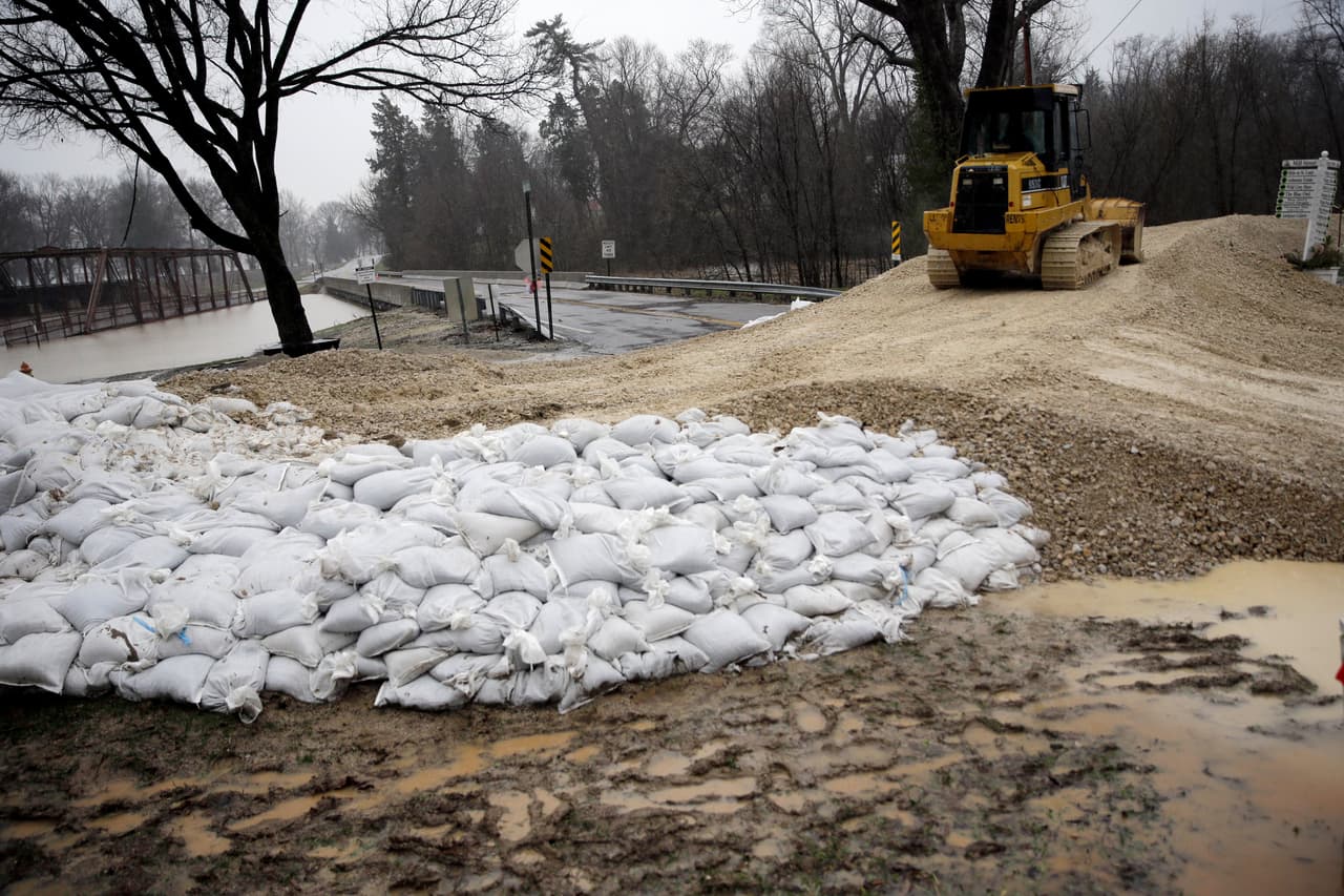 Una excavadora se utiliza para construir un dique temporal que permita retener el agua de la inundación, en Missouri.