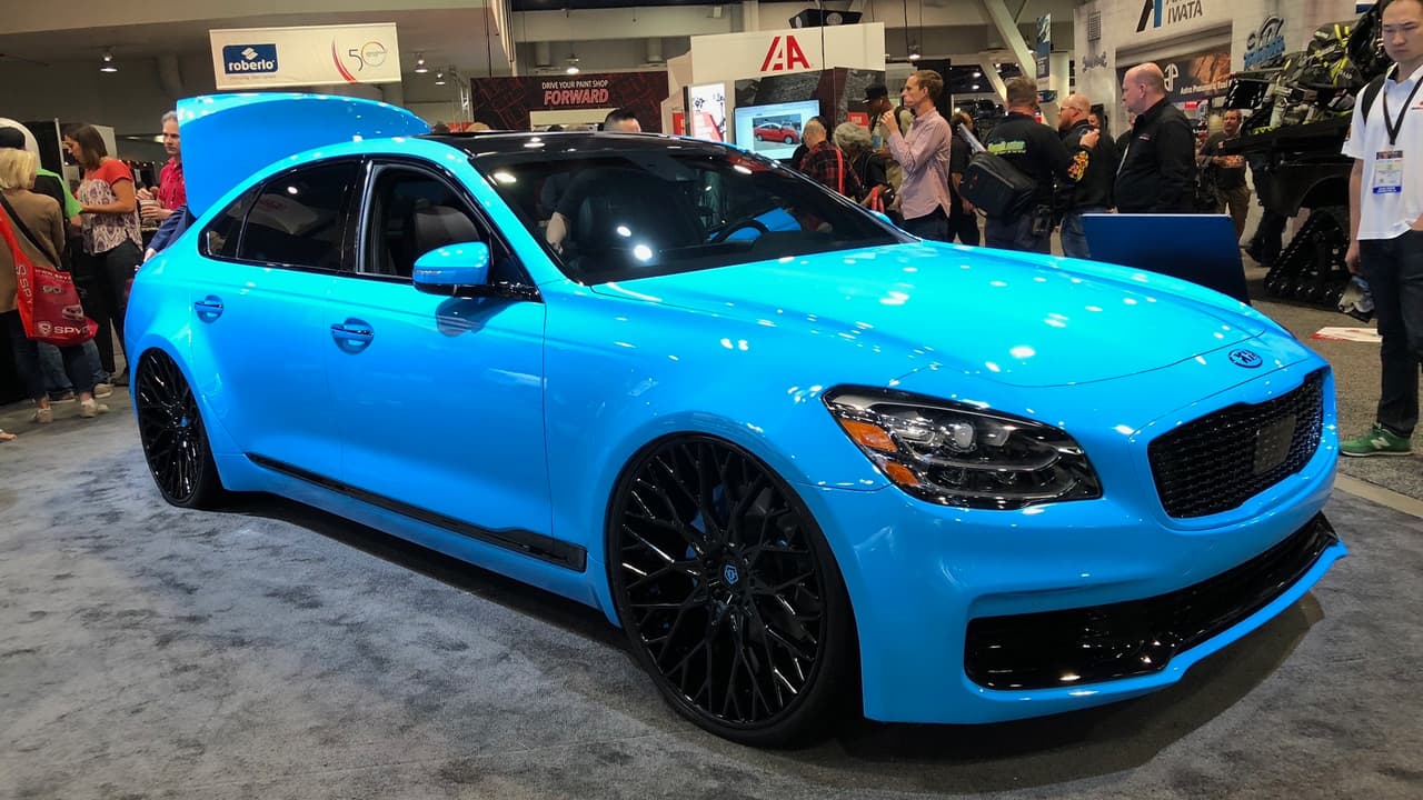 <h3 class="cms-h3-H3">Kia K900 2019 personalizado por DUB</h3>
<br>Fue interesante ver por primera vez al nuevo Kia K900 2019 ya personalizado. Aunque el trabajo de DUB deja bastante que desear, las enormes ruedas de 24 pulgadas se sientes pasadas de moda y el exceso de azul 'pitufo' le da a todo el conjunto un aura genérica que no creo que era lo que se buscaba, el conjunto funciona extrañamente bien.