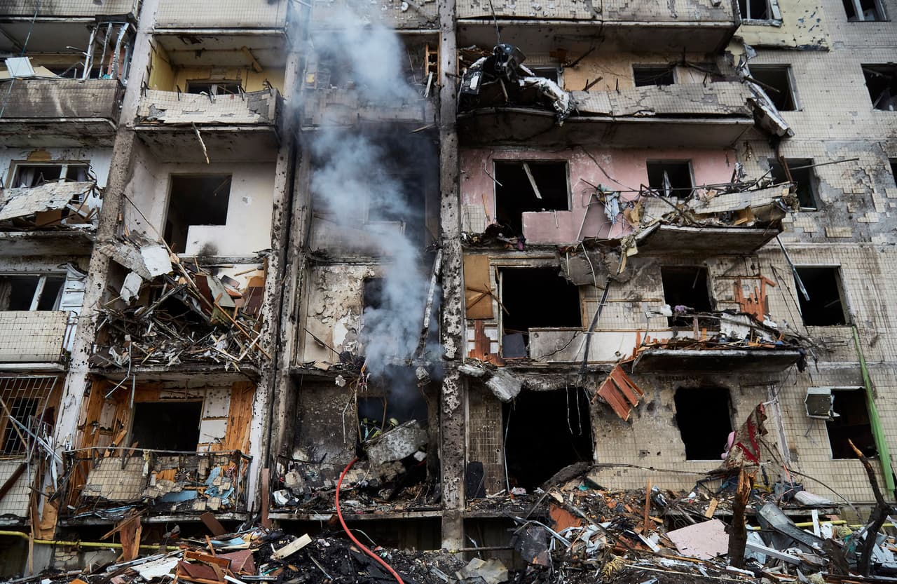 Los bomberos intentando extinguir un edificio residencial de Kiev que resultó en llamas al ser golpeado por un misil ruso, el 25 de febrero. La agencia de la ONU estima que hasta 4 millones de personas podrían abandonar el país, que tiene 44 millones de habitantes.