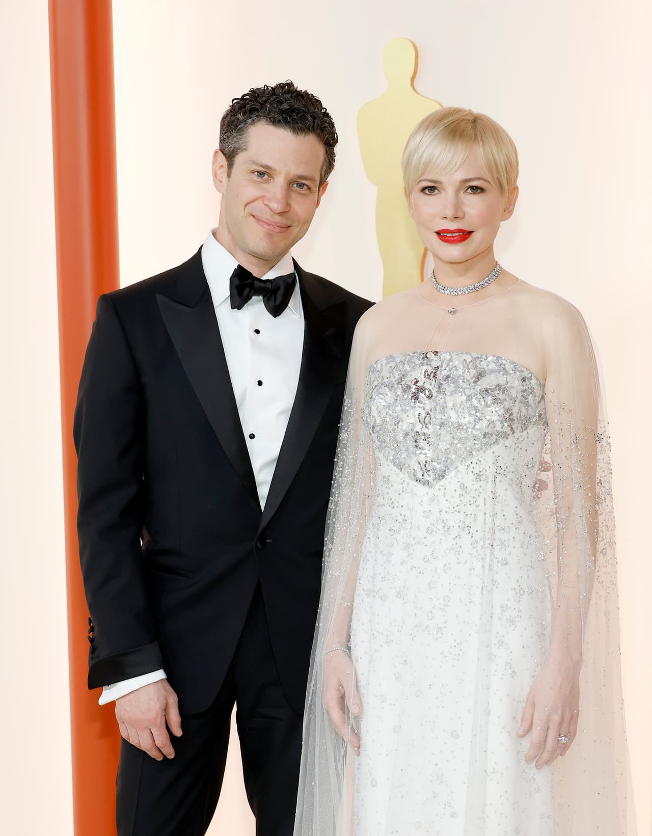 Thomas Kail y Michelle Williams en la alfombra champagne de los Premios Oscar 2023