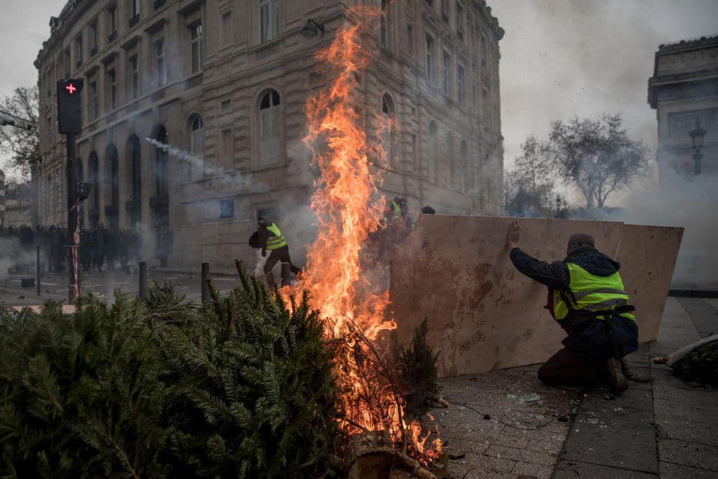 Al lado de una barricada arde un árbol de navidad tomado de un restaurante parisino durante la protesta.