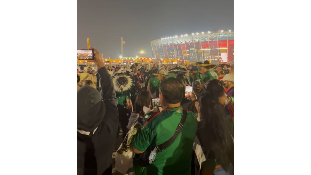 Aficionados mexicanos bailan "Payaso de rodeo" afuera de uno de los estadios de Qatar.