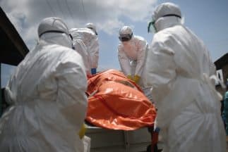 Trabajadores de salud en Liberia retiran el cuerpo de una mujer, víctima del brote que azota al país africano.