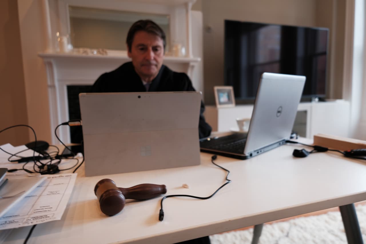 <b>La corte en casa.</b> Paul McDonnell, juez penal de la ciudad de Nueva York, atiende sus casos de la corte de Manhattan por video llamda desde su departamento de Brooklyn, donde trabaja vestido con su túnica oficial. Aunque continúa trabajando a tiempo completo, el juez ha visto que la crisis ha ralentizado el sistema de justicia en la ciudad. 9 de abril.