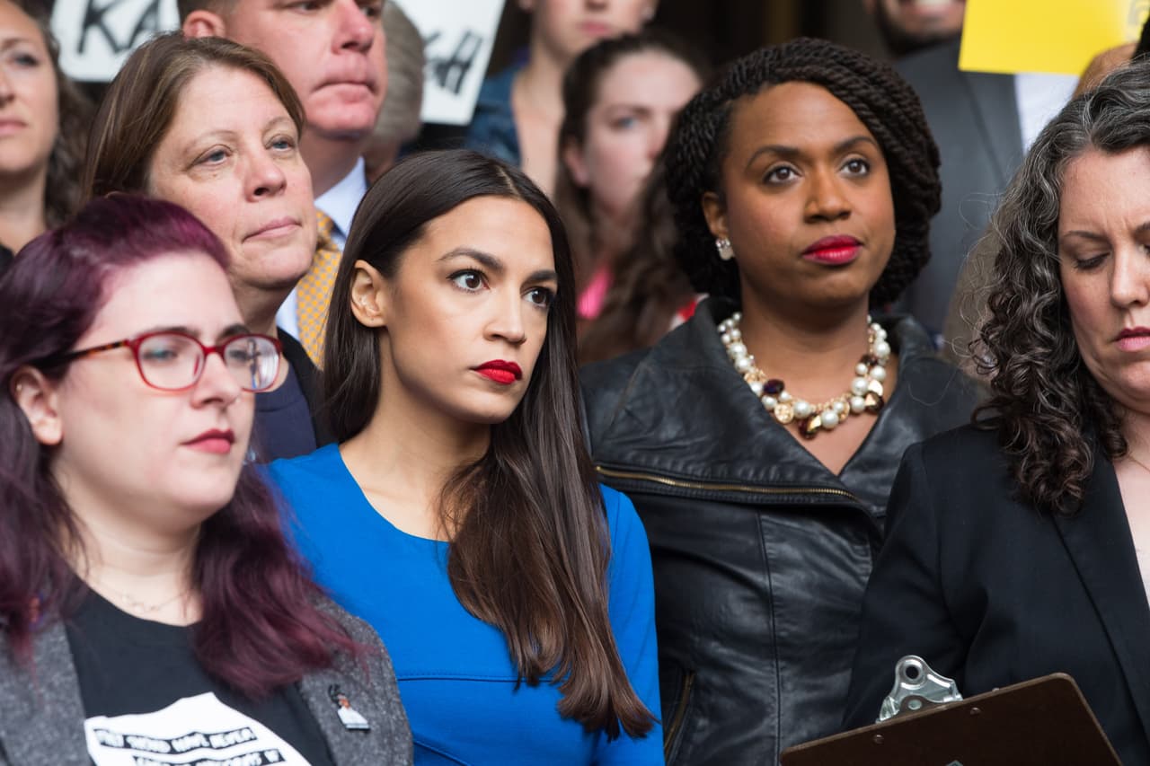 BOSTON, MA - OCTOBER 01: New York Democratic congressional candidate Alexandria Ocasio-Cortez (in blue) stands with Boston City Councilor and Democratic congressional candidate Ayanna Pressley (R) at a rally calling on Sen. Jeff Flake (R-AZ) to reject Judge Brett Kavanaugh's nomination to the Supreme Court on October 1, 2018 in Boston, Massachusetts. Sen. Flake is scheduled to give a talk at the Forbes 30 under 30 event in Boston after recently calling for a one week pause in the confirmation process to give the FBI more time to investigate sexual assault allegations. (Photo by Scott Eisen/Getty Images)