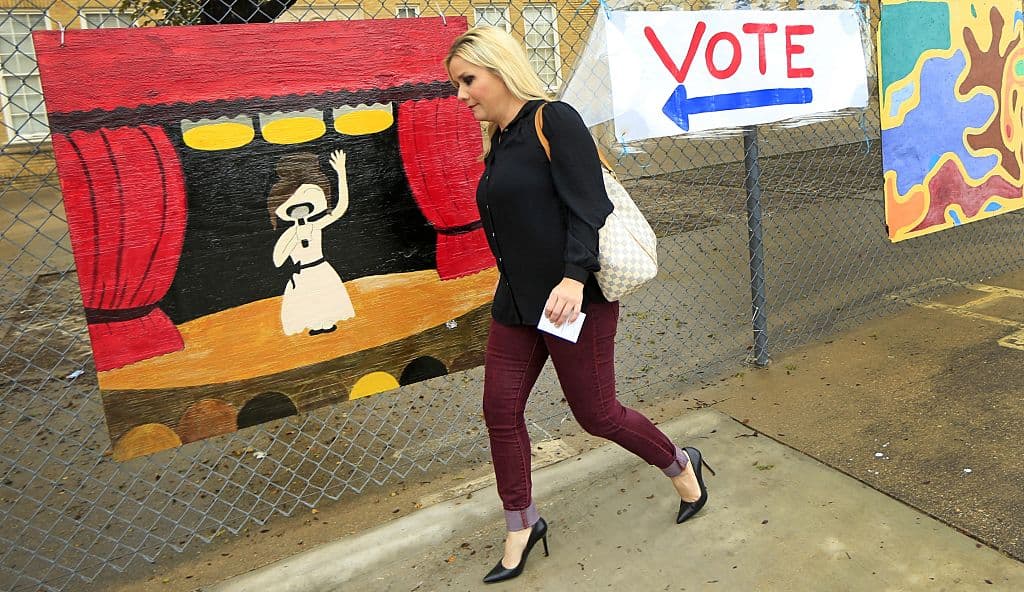 La votante Christi Selleck pasa por un cartel de señalización hecho a mano por niños de primaria en Fort Worth, Texas, el 8 de noviembre de 2016. Foto: Ron Jenkins.