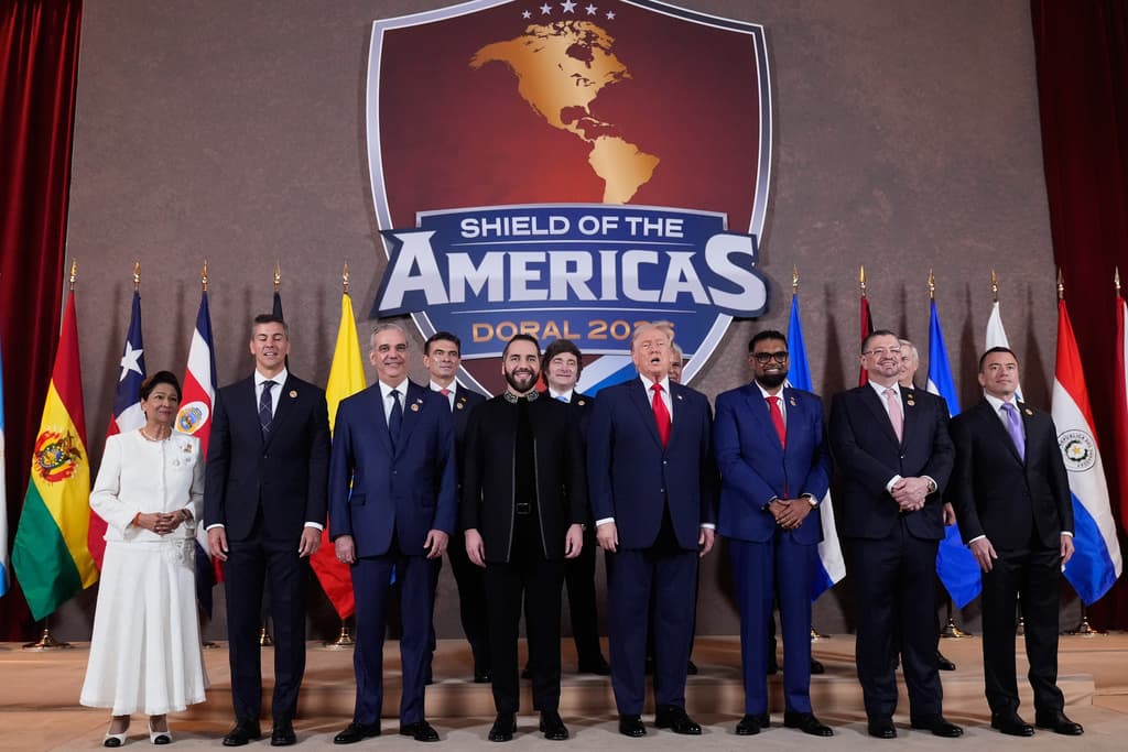 Primera fila, de izquierda a derecha: la primera ministra de Trinidad y Tobago, Kamla Persad-Bissessar; el presidente de Paraguay, Santiago Peña; el presidente de la República Dominicana, Luis Abinader; el presidente de El Salvador, Nayib Bukele; el presidente Donald Trump; el presidente de Guyana, Mohamed Irfaan Ali; el presidente de Costa Rica, Rodrigo Chaves Robles; el presidente de Ecuador, Daniel Noboa; en la fila de atrás, de izquierda a derecha, el presidente de Bolivia, Rodrigo Paz Pereira; el presidente de Argentina, Javier Milei; el presidente de Panamá, José Raúl Mulino; el presidente de Honduras, Nasry Asfura (no visible), y el entonces presidente electo de Chile, José Antonio Kast (parcialmente visible), posan para una foto grupal en la Cumbre del Escudo de las Américas, el sábado 7 de marzo de 2026, en el Trump National Doral Miami, en Doral, Florida.