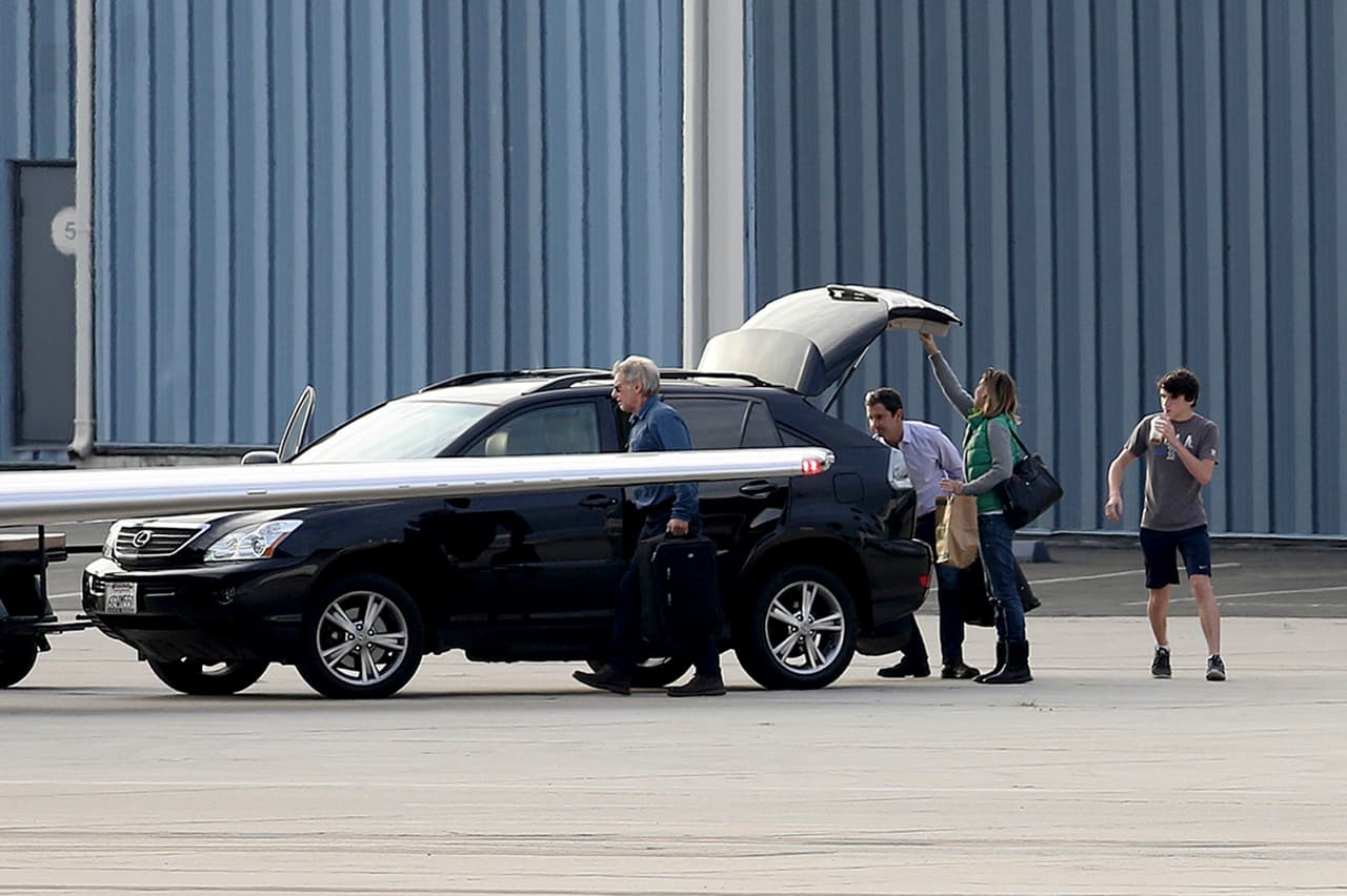 Todos sacaban sus maletas del coche, alistándose para abordar.
