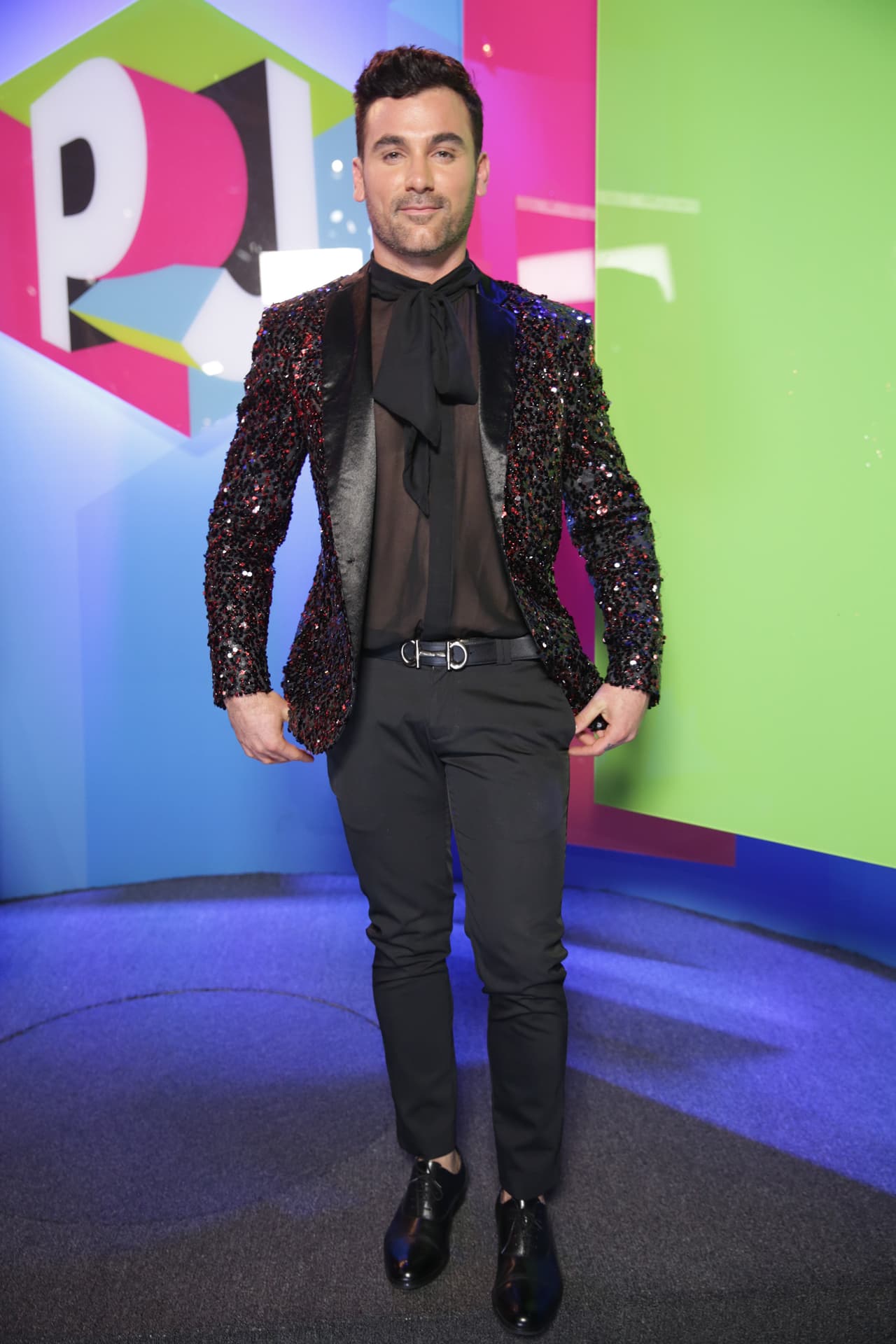 El actor Mauricio Mejía utilizó una camisa negra traslúcida, que adornó con un moño largo.