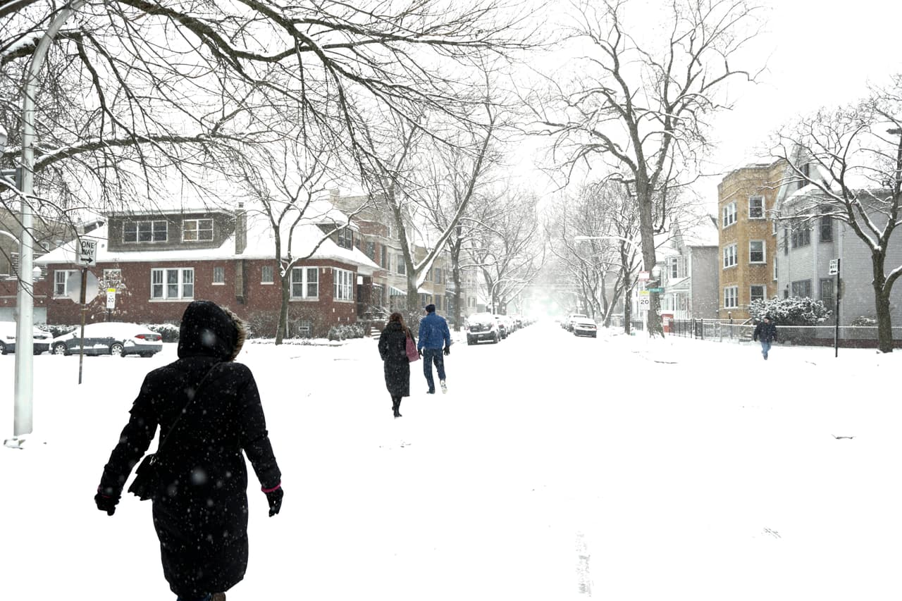 Vecinos caminan sobre la nieve en las calles del barrio Lakeview, en Chicago, Illinois.