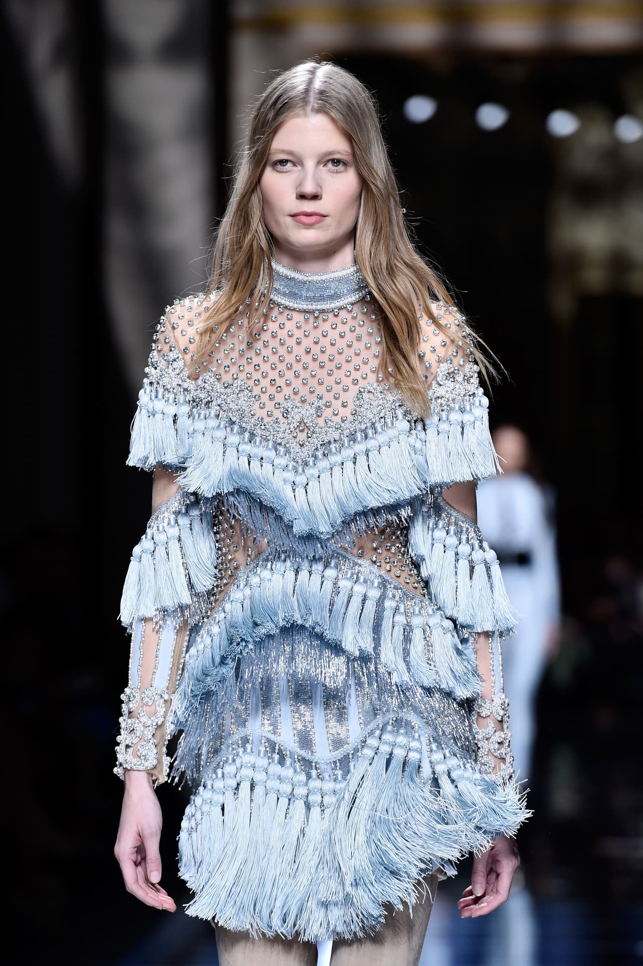 Empecemos por principios de siglo y vayamos a década de los 1900: No es tu Gibson Girl de ayer. Para su colección otoño-invierno 2016-17, Balmain tomó elementos icónicos de la Belle Epoque como los cuellos altos, las aplicaciones y las telas diáfanas, para darles un giro sensual e inesperado al subir los vestidos hasta límites de escándalo y llenarlos de hilera tras hilera de divertidas borlas.