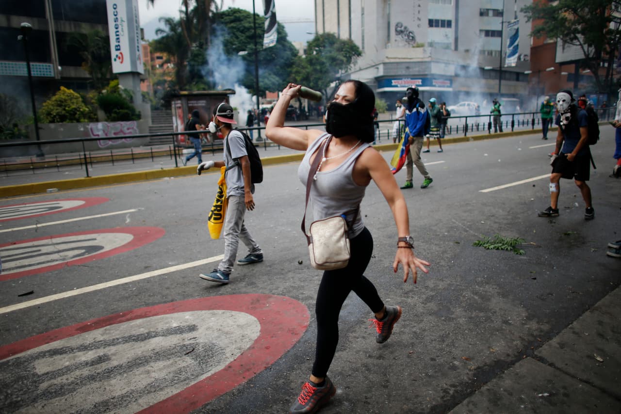 A woman throw a spent tear gas canister at police. April 20, 2017.