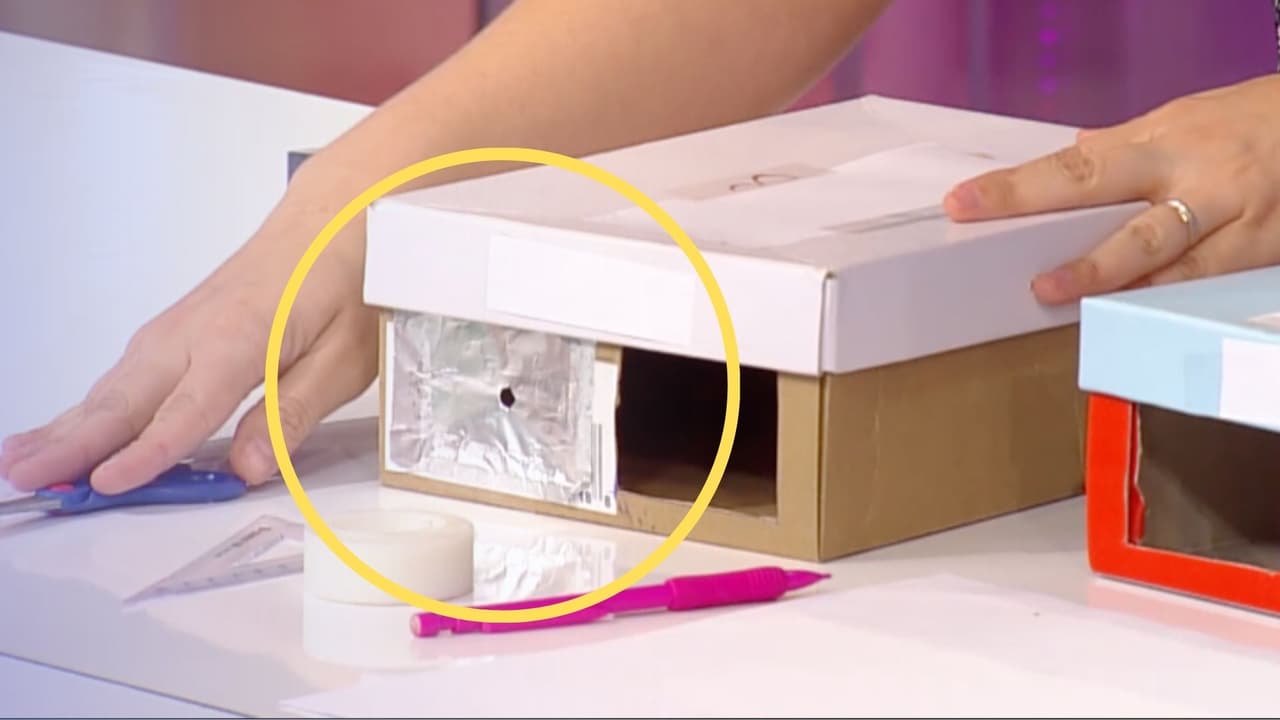 <b>Pasos para construir tu "caja oscura": </b>
<br>
<b>1. Preparación de la caja: </b>Utilizando la regla y las tijeras, corta dos rectángulos en la caja. 
<br>
<b>2. Cubrir un rectángulo con papel de aluminio:</b> Recorta un trozo de papel de aluminio para cubrir uno de los rectángulos. 
<br>
<b>3. Preparación interna:</b> Corta una parte de la hoja de papel con las mismas dimensiones que el lado trasero de la caja, y colócala dentro, en el lado opuesto a los rectángulos.