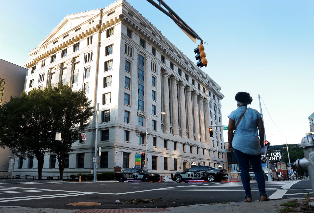 ATLANTA, GEORGIA - AUGUST 08: People walk near the Fulton County Courthouse as more security has been put in place on August 08, 2023 in Atlanta, Georgia. The heightened security is in place as Fulton County District Attorney Fani Willis is expected to announce soon a possible grand jury indictment in her investigation into former President Donald Trump and his Republican allies' alleged attempt to overturn the 2020 election in the state. (Photo by Joe Raedle/Getty Images)