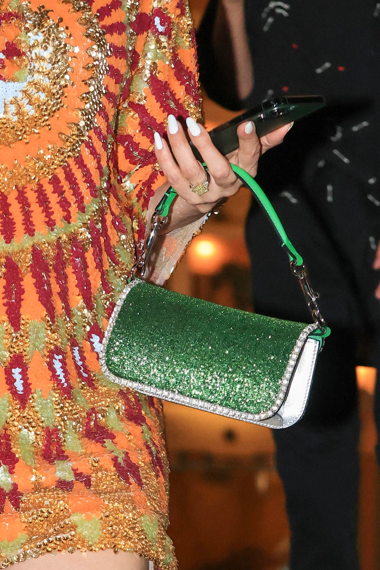 Traía un pequeño bolso verde de mano plagado de lentejuelas.
<br>